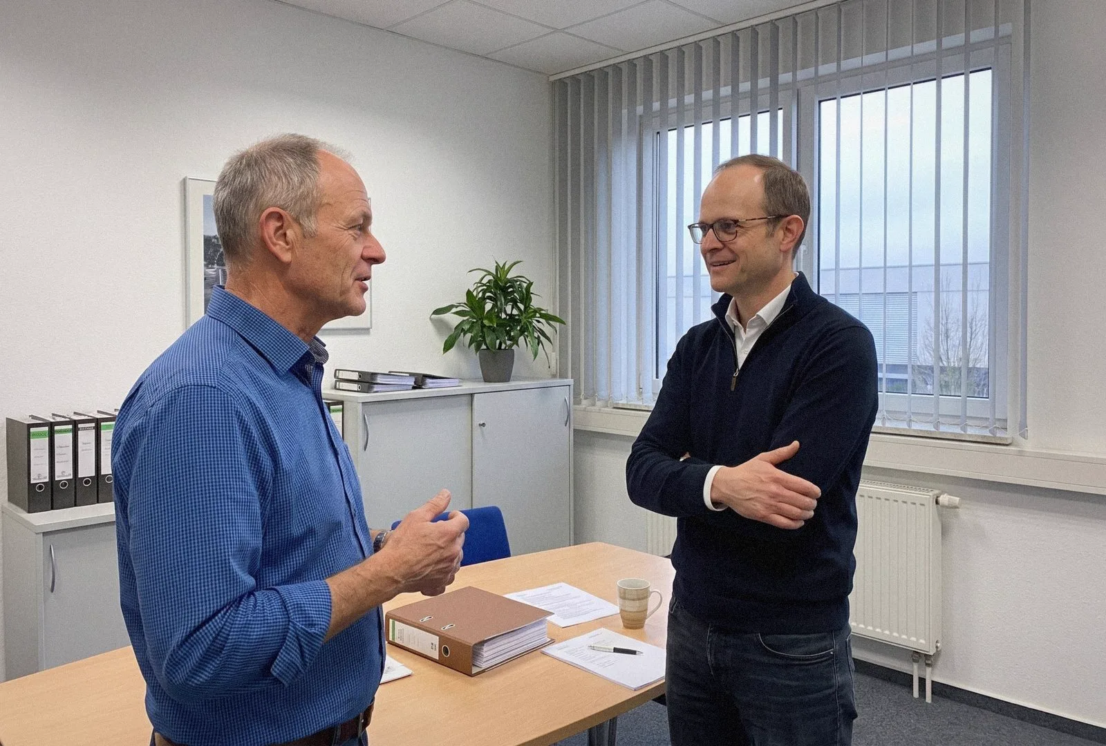 Dr. Ralf Schmelter im Gespräch mit einem Unternehmer im Büro eines mittelständischen Betriebs